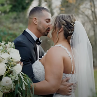 A bride and groom share an intimate moment in a garden setting during golden hour, with the bride holding a white floral bouquet.