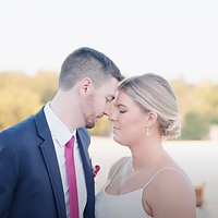 A bride and groom share a tender kiss during golden hour at an outdoor wedding location.