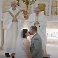 A bride and groom exchange vows during a wedding ceremony while clergy members conduct the service in a traditional church setting.