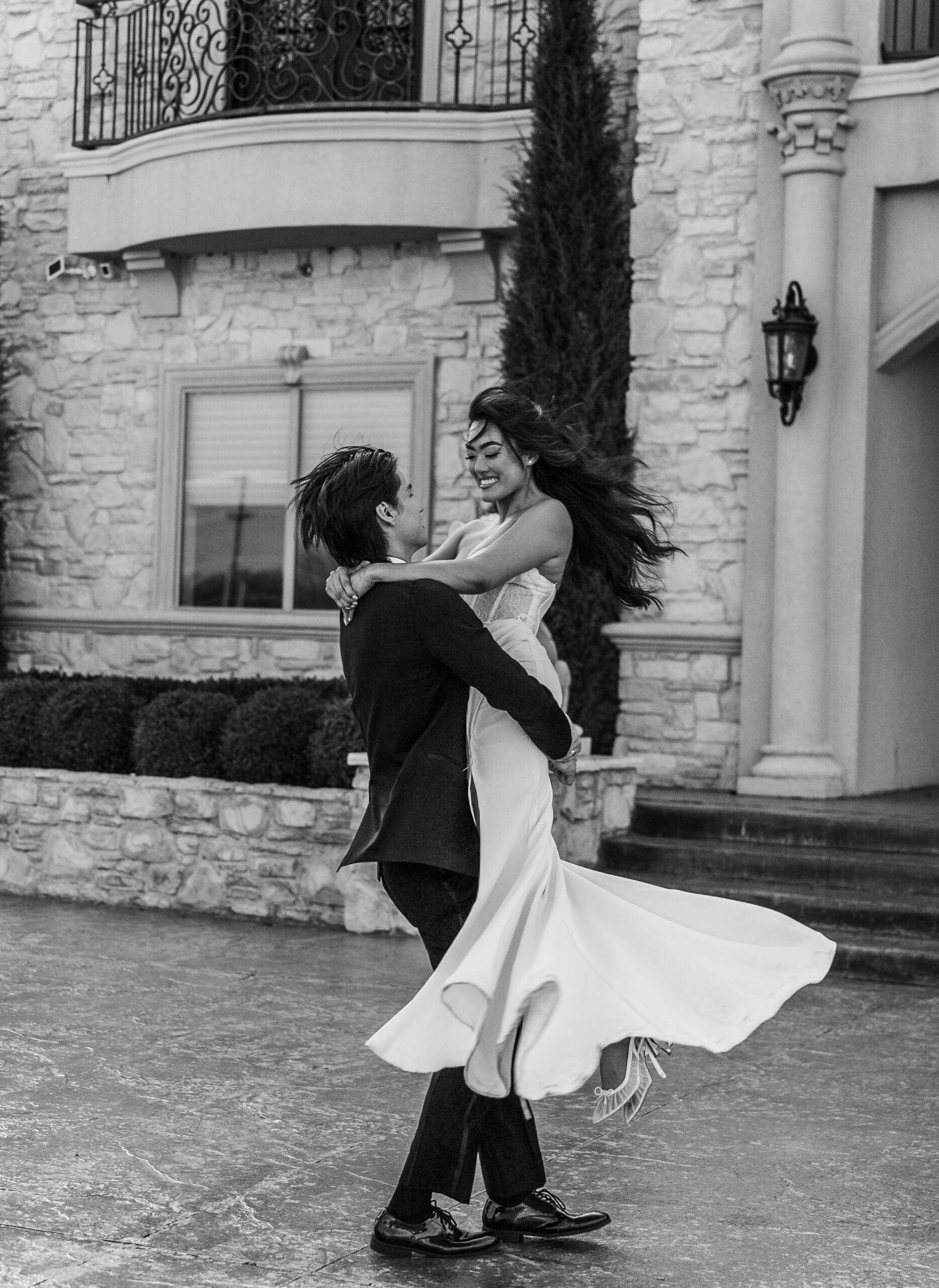 Couple dancing together in front of a stone building