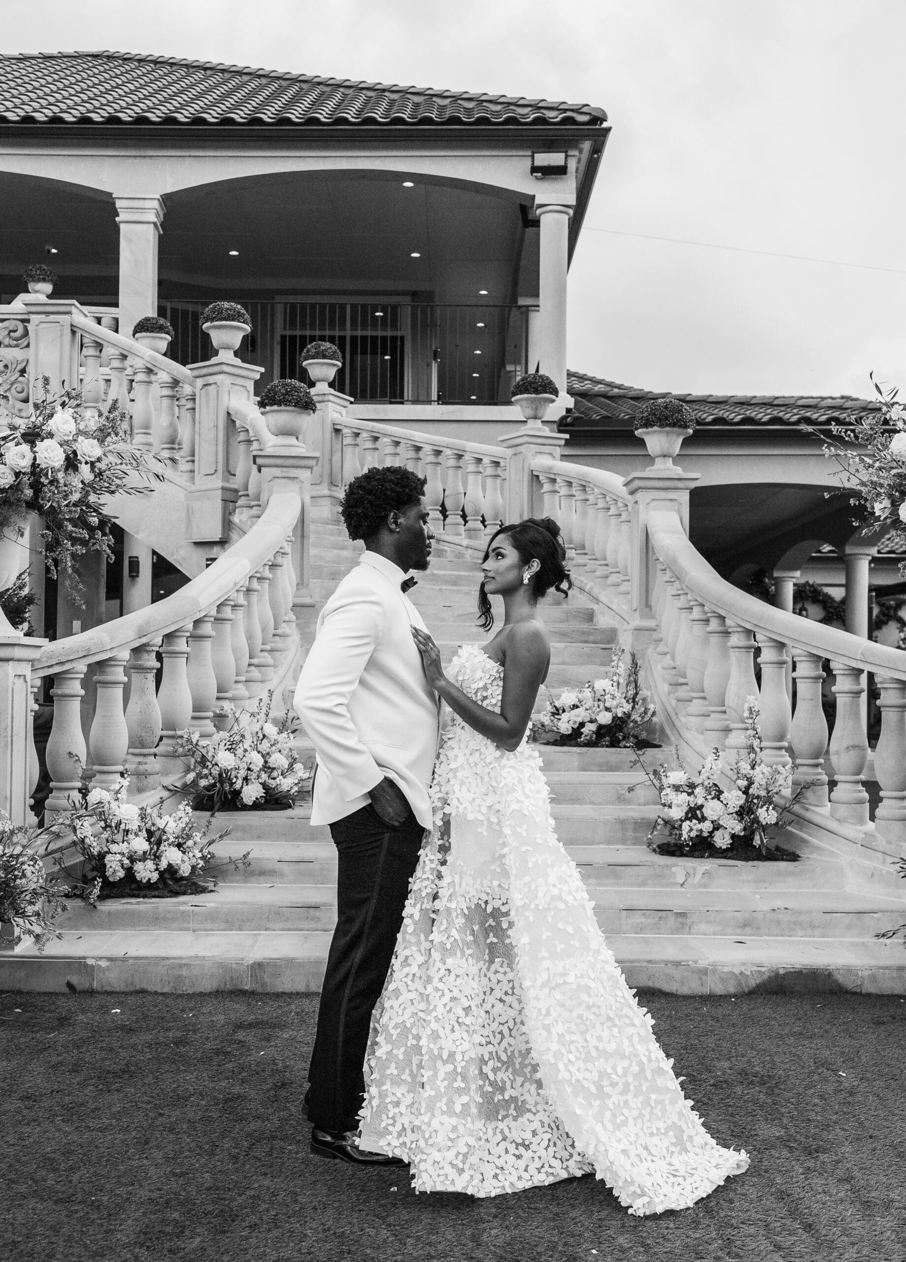 Bride and groom in an elegant black and white portrait on a grand staircase