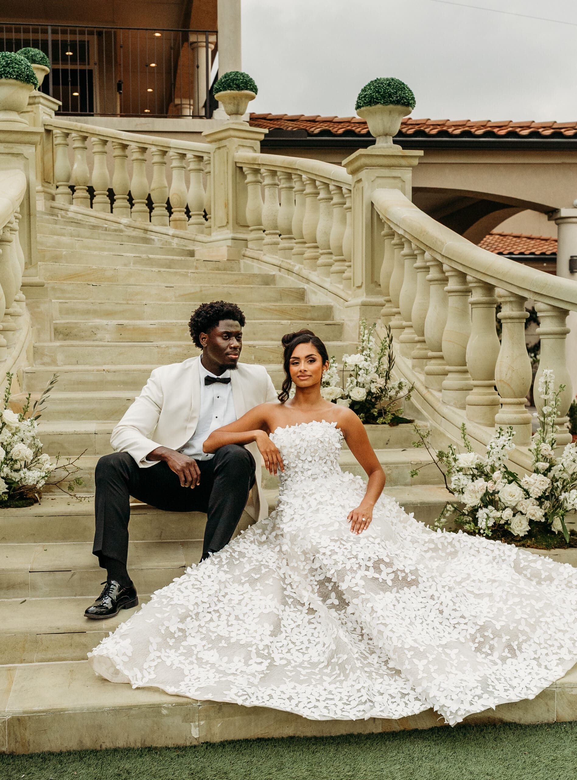 Bride and groom posing on an elegant stone staircase